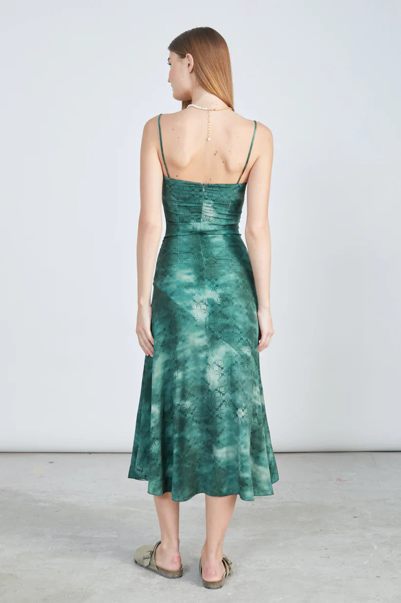 Stylish emerald satin dress featuring soft draped fit and modern effortless resort-inspired fashion appeal.