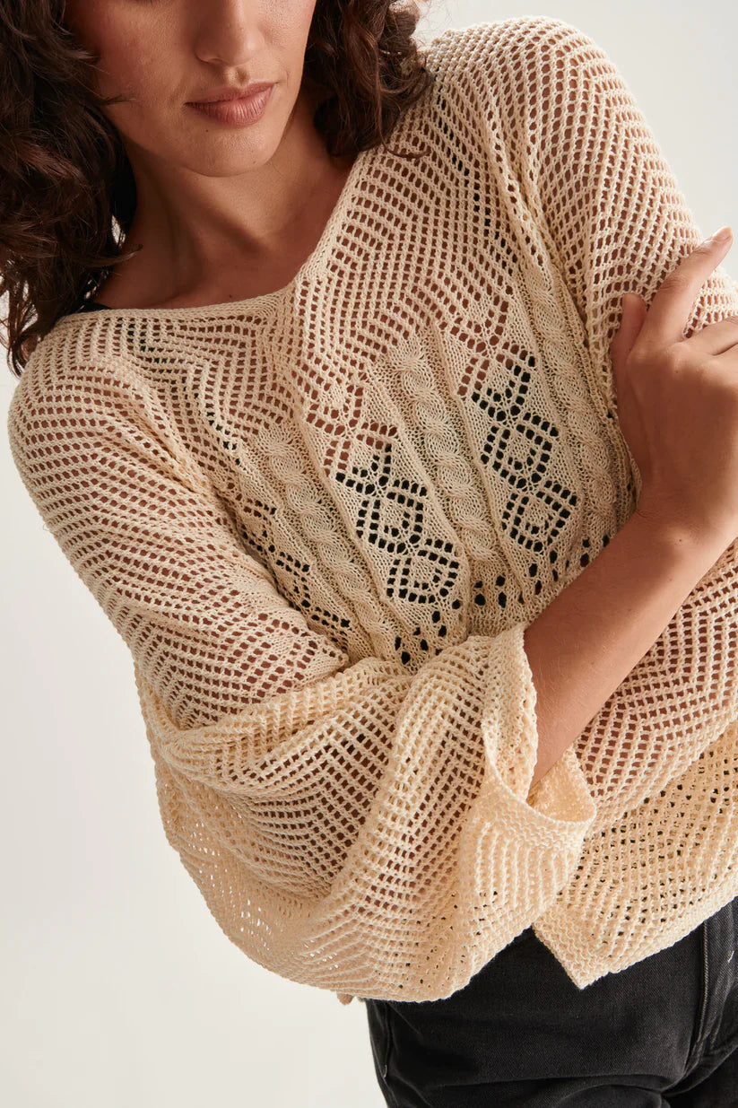 Women’s oversized crochet pullover with intricate cable knit details and slouchy sleeves for modern coastal style.