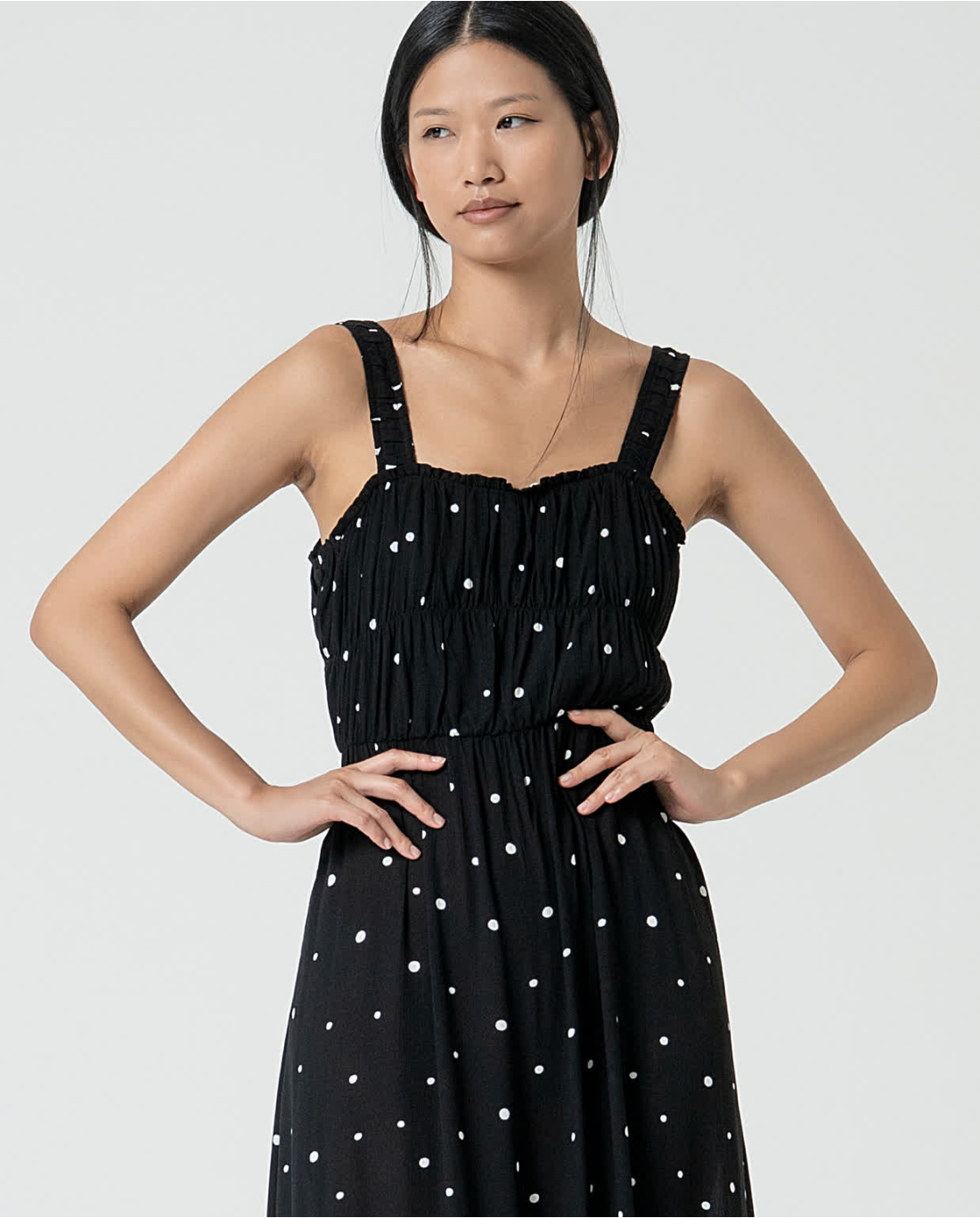 Women’s breezy black polka dot dress with gathered waist detail and effortless modern elegance.