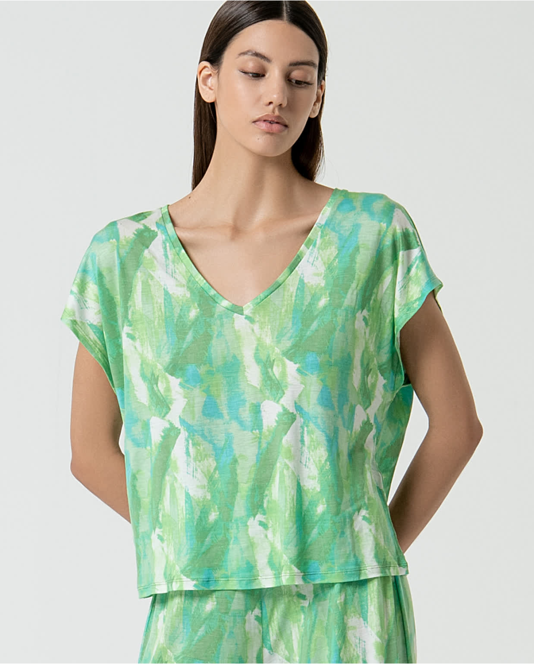 Boutique-style abstract print V-neck tee with soft green and aqua tones for fresh summer outfits.