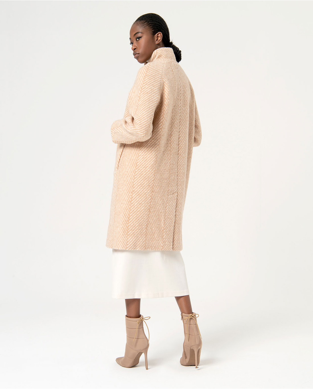 Sophisticated longline beige coat with oversized fit and contemporary quiet luxury fashion aesthetic.