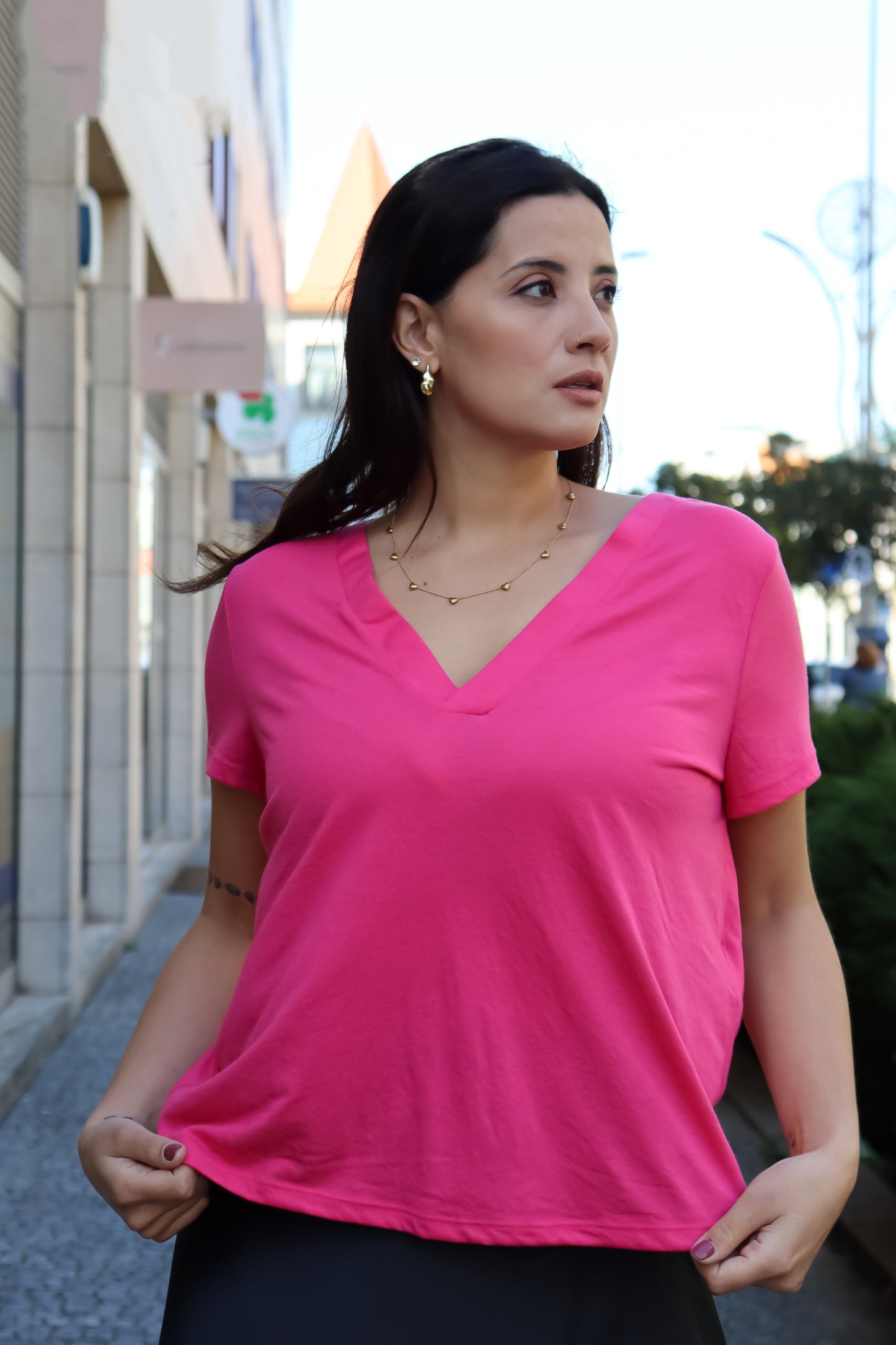 Chic pink V-neck t-shirt with lightweight drape and contemporary minimalist boutique fashion appeal.