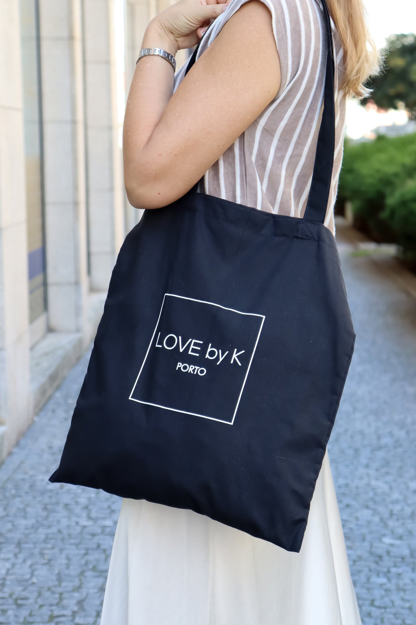 Large black shopper tote with contemporary logo Love By K design and functional minimalist fashion appeal.