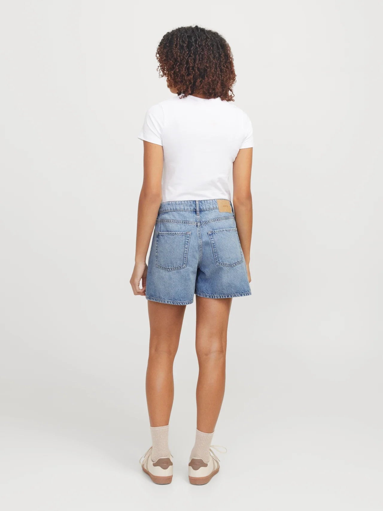 Back view of Trend-driven light wash denim shorts with effortless everyday styling and timeless silhouette.