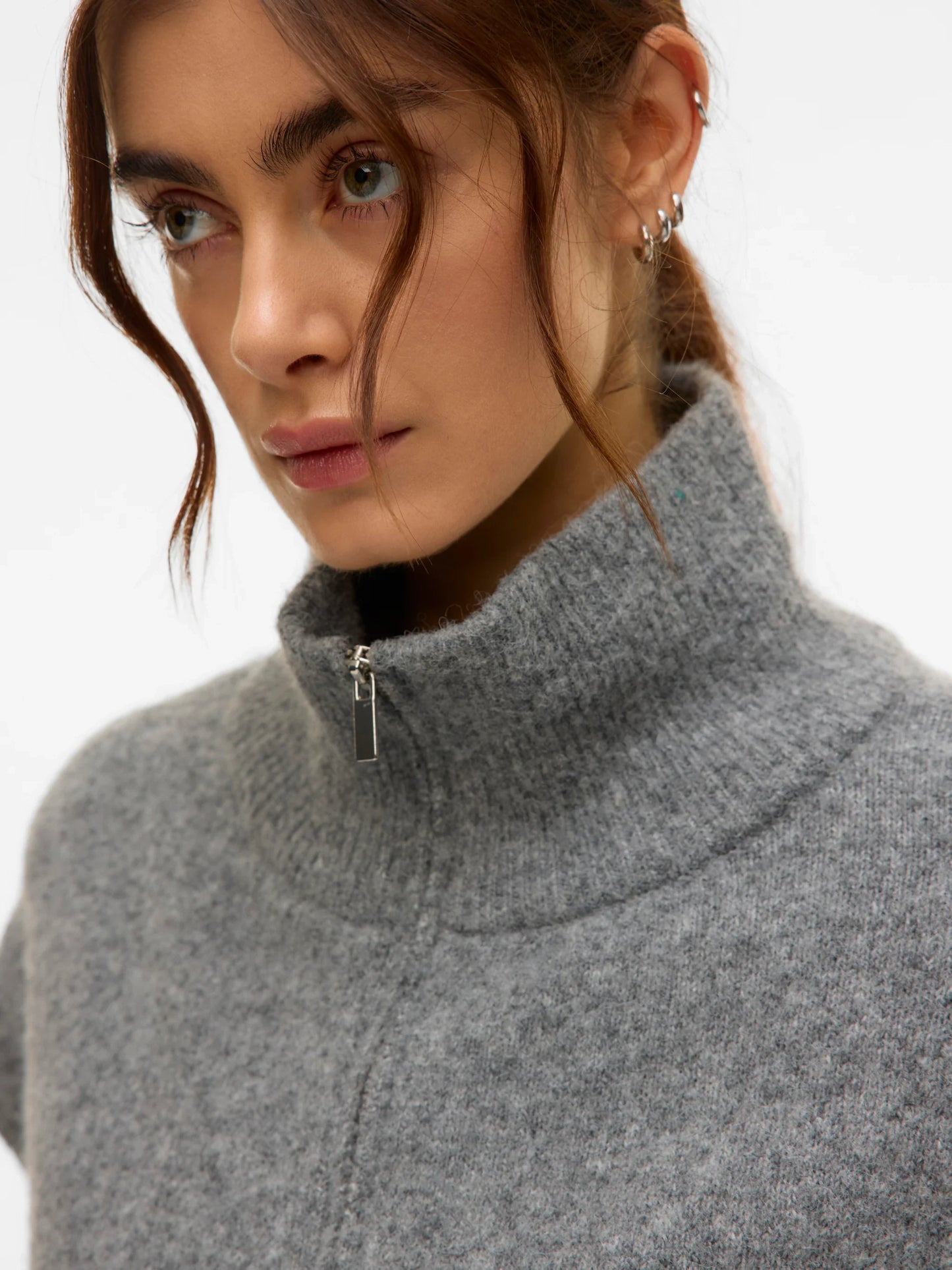 Close up detail of fashion-forward grey knit vest with soft textured finish and zip detail