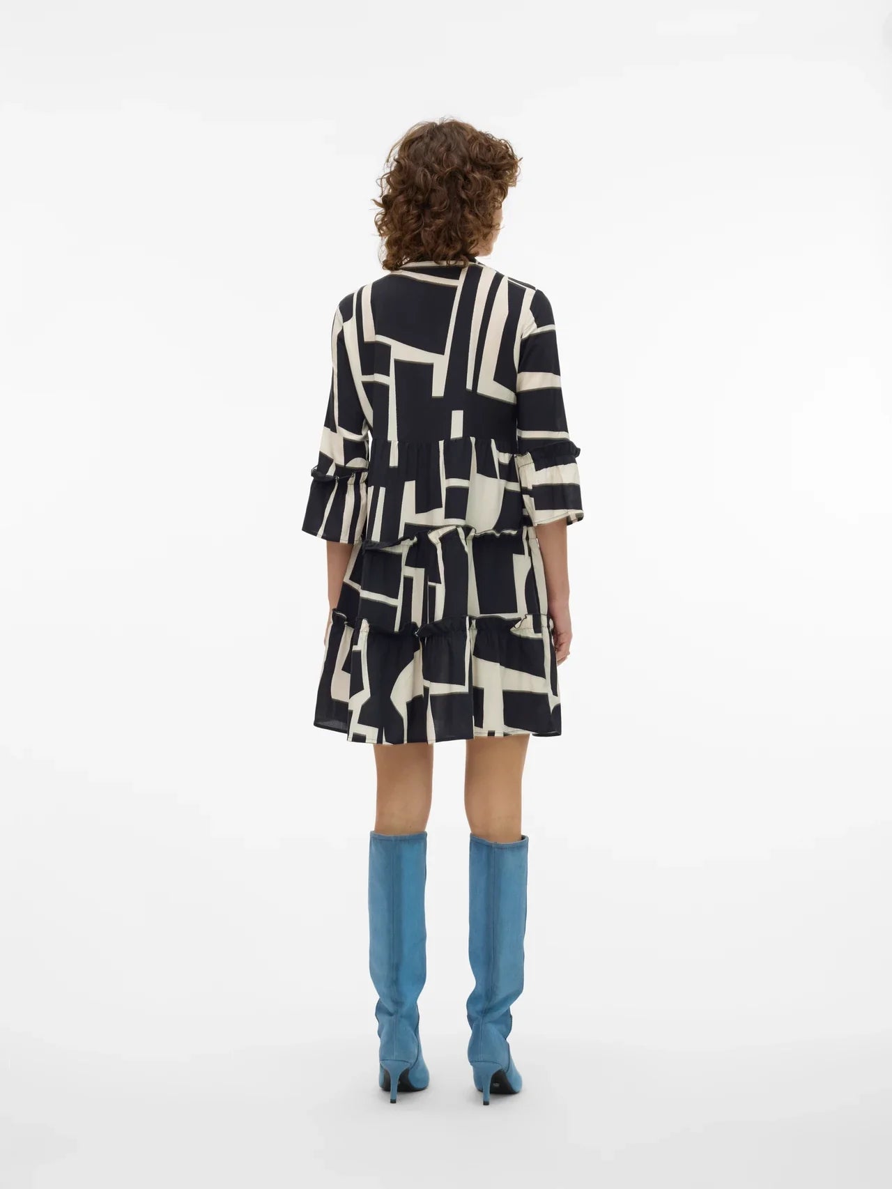 Contemporary flowy tunic dress with monochrome abstract design and layered ruffle trim for elevated everyday wear.