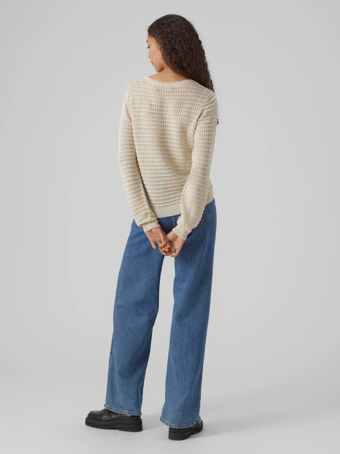 Soft ivory pointelle sweater featuring lightweight knit fabric and long sleeves for elegant casual women’s style.