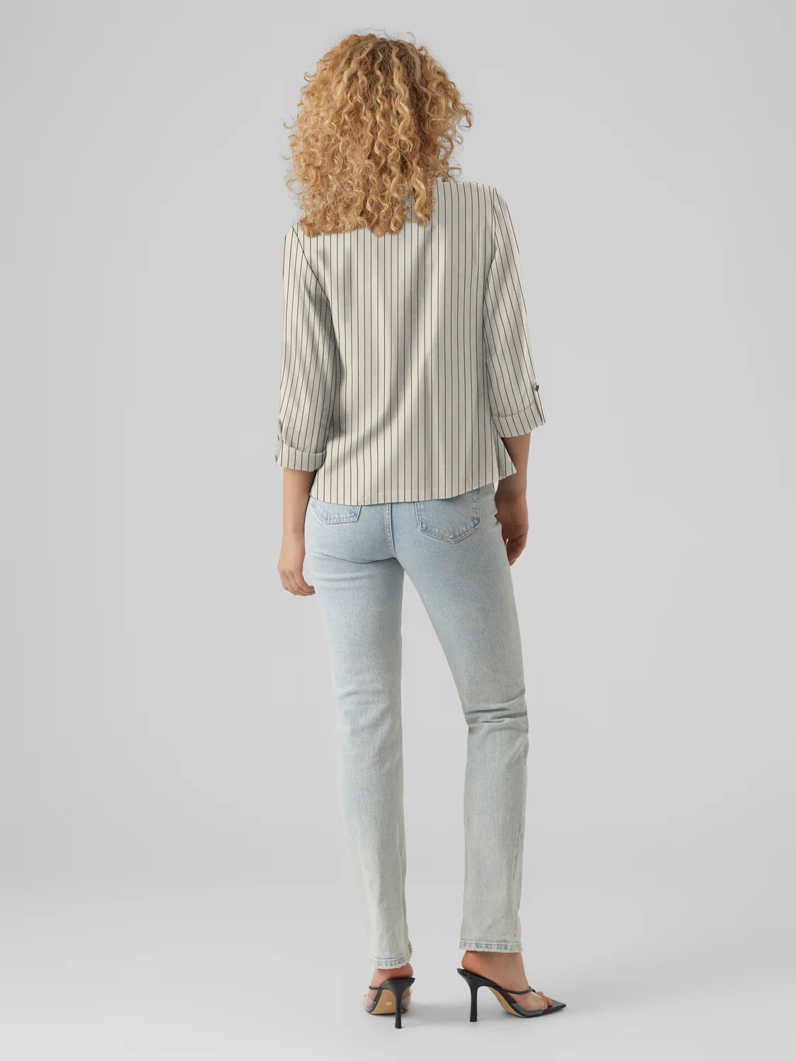 Back silhouette of elegant women’s tailored pinstripe blazer featuring rolled sleeves and contemporary neutral-tone sophistication.