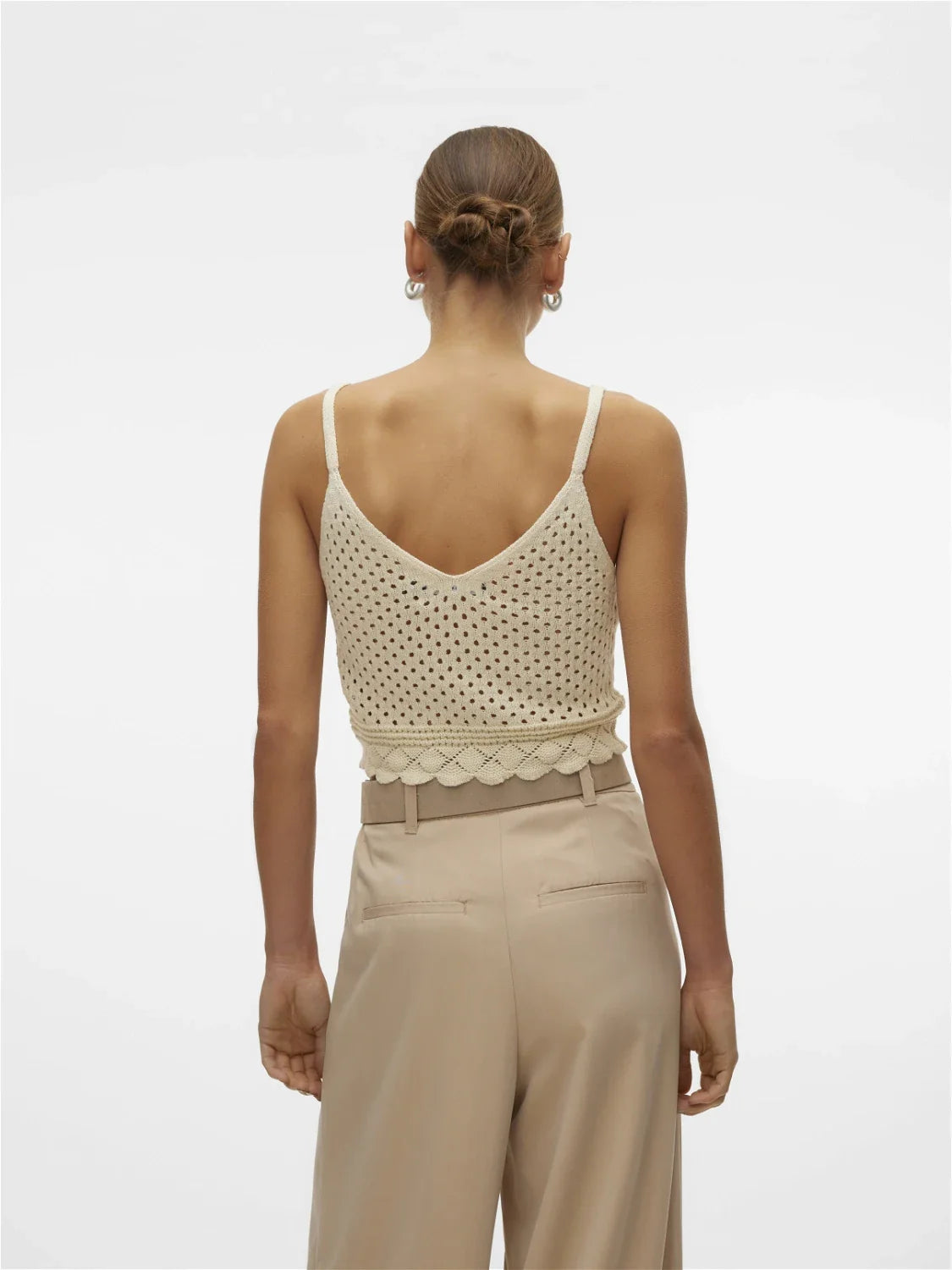 Fashion-forward crochet crop camisole featuring delicate open weave and feminine fitted silhouette for trendy summer wardrobes.