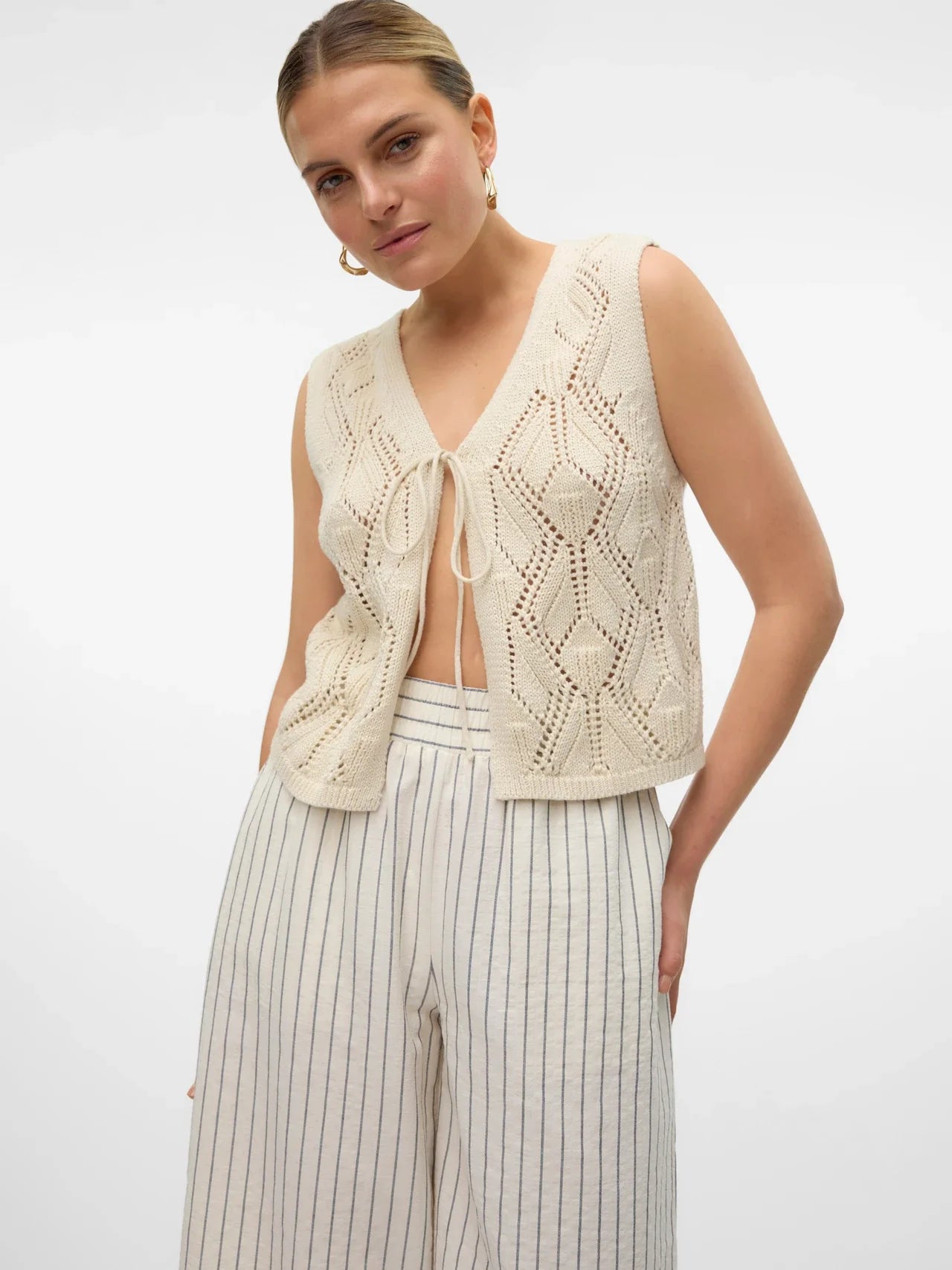 Elevated sleeveless knit tank with intricate textured pattern and contemporary fashion-forward silhouette.