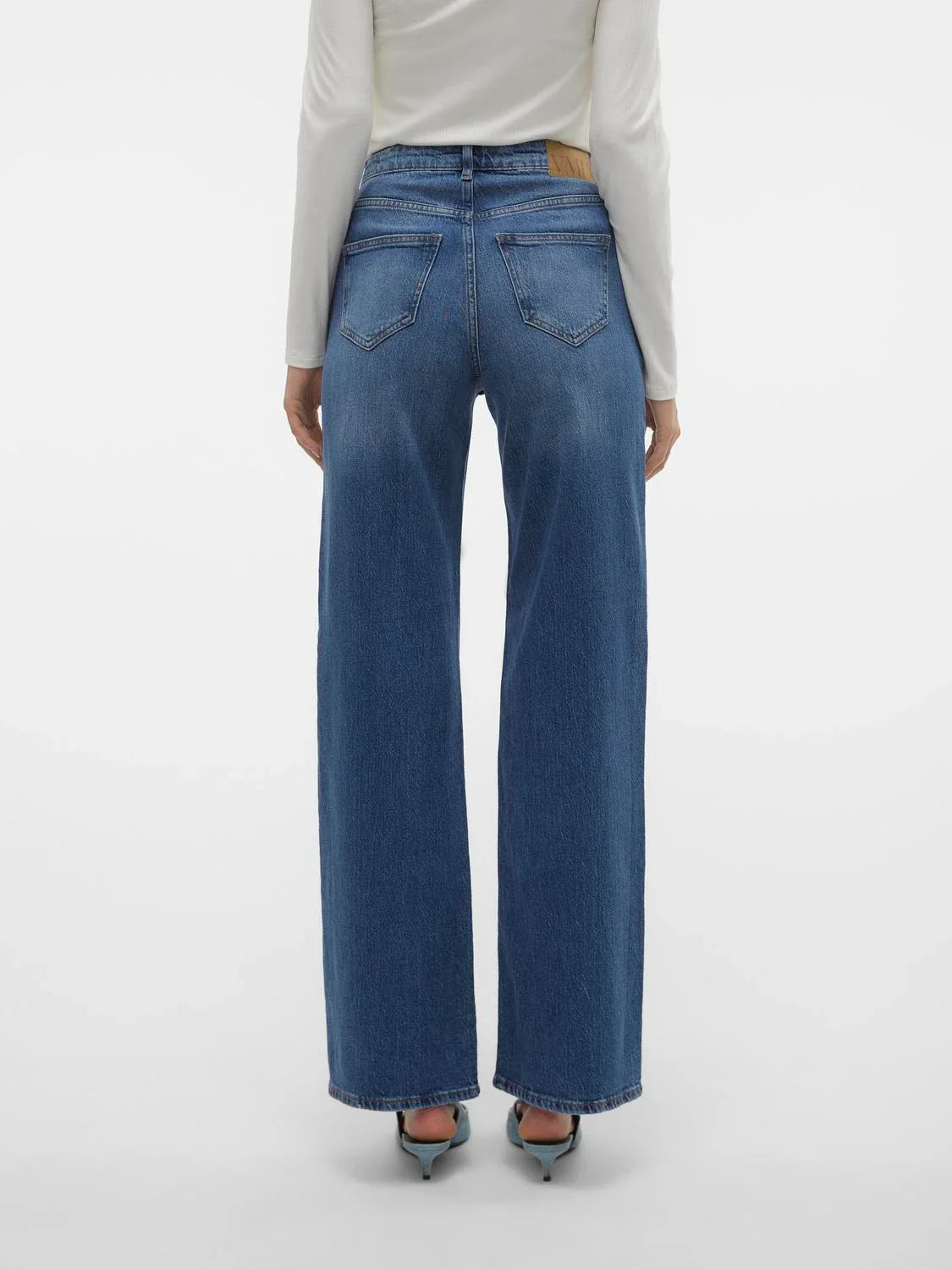 Back view of timeless blue denim jeans with high-rise waist and relaxed straight leg fit for modern women’s fashion.