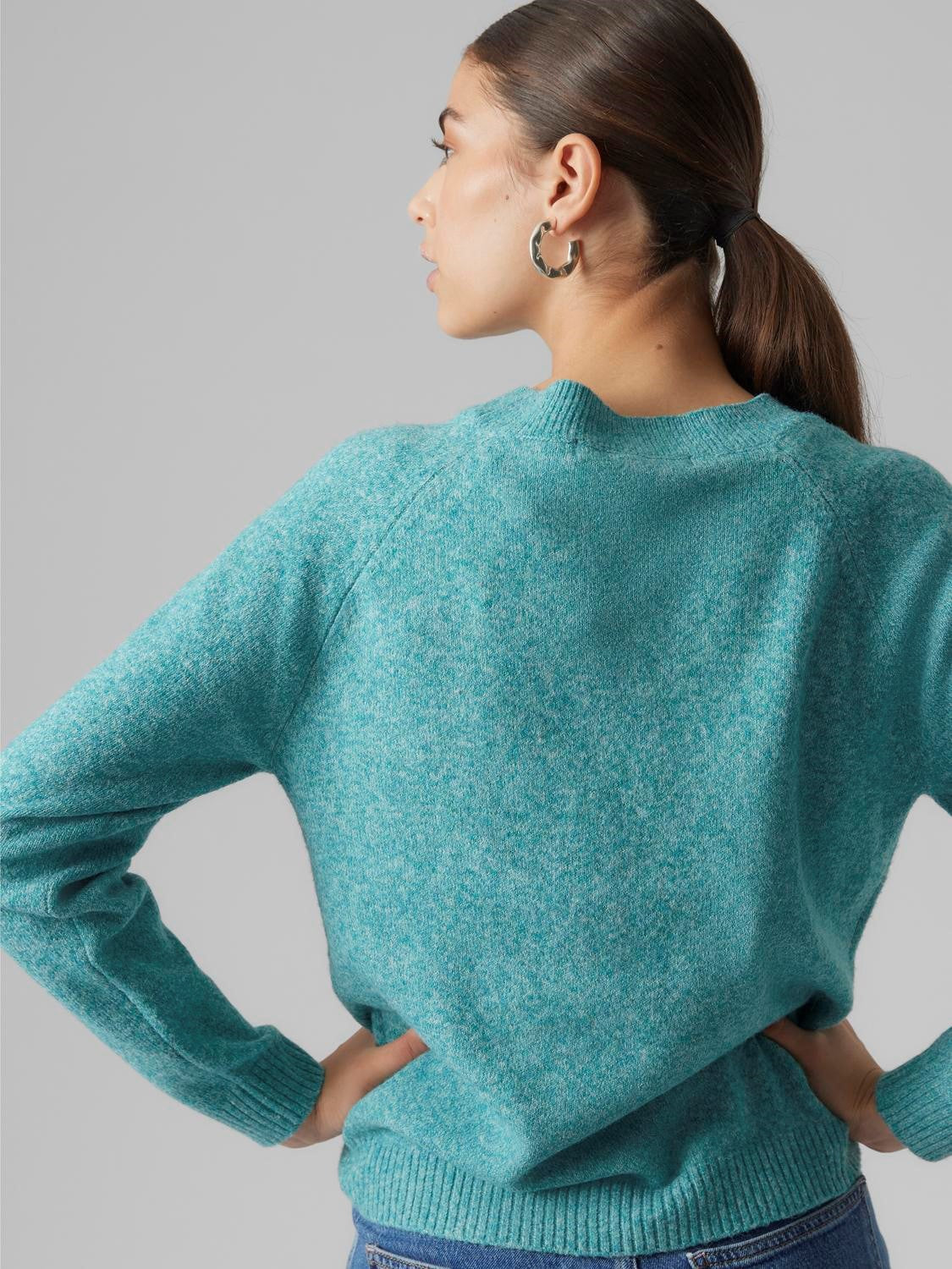 Relaxed-fit women’s teal knit jumper with cozy texture and understated modern fashion design.