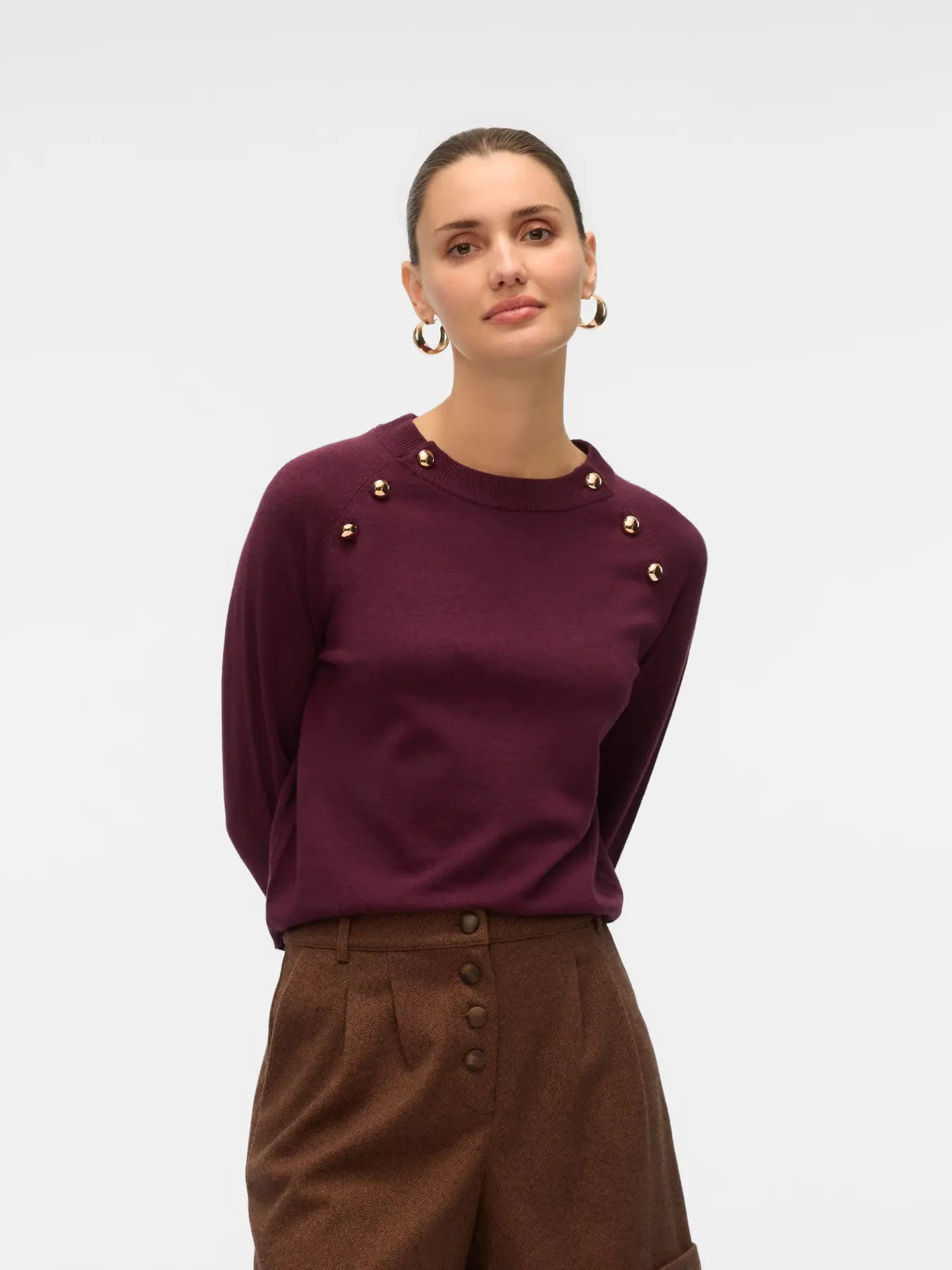 Women's burgundy crew neck knit sweater with decorative gold-tone shoulder buttons and long sleeves for elevated everyday outfits.