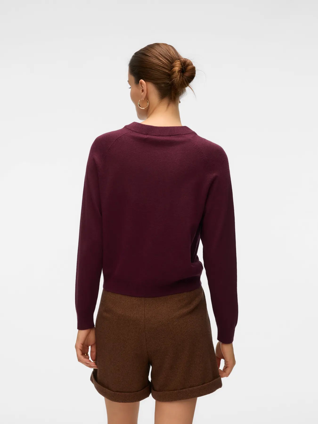Women's deep plum crew neck sweater with long sleeves and decorative metallic gold button accents.