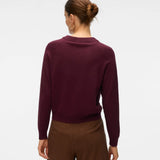 Women's deep plum crew neck sweater with long sleeves and decorative metallic gold button accents.