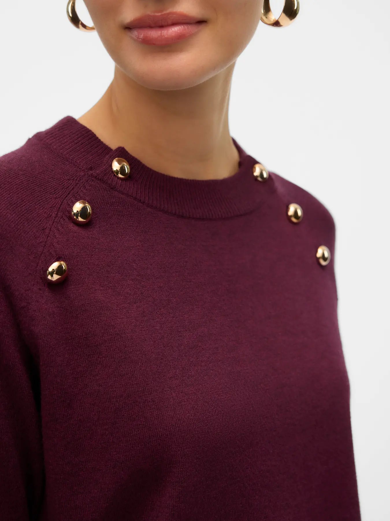 Women's wine red long-sleeve sweater featuring statement gold button details around the neckline for sophisticated casual styling.