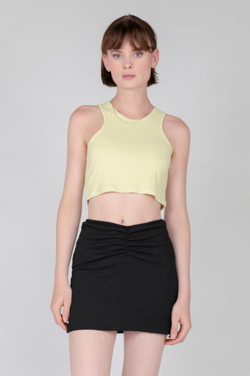 Pale yellow fitted crop top with sleeveless construction and sporty-chic aesthetic.