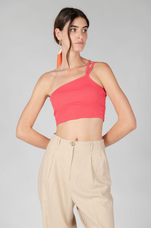 Trendy asymmetrical sleeveless crop top in vibrant coral pink for summer and vacation outfits.