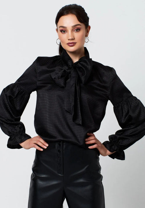 Elegant black textured blouse featuring voluminous sleeves and statement neck bow.