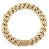 Artisan-inspired woven smooth hair tie with textured braid pattern and earthy green tones for laid-back fashion looks.