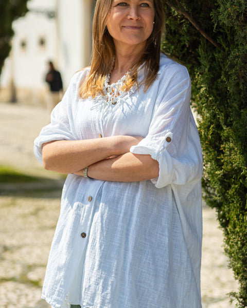 Fashion-forward relaxed linen blouse dress with rolled sleeves and minimalist summer styling.