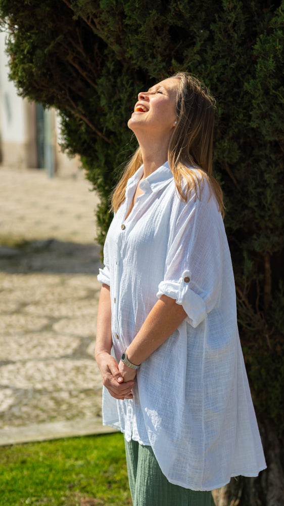 Chic oversized white beach shirt with airy texture and elevated Mediterranean vacation fashion appeal.