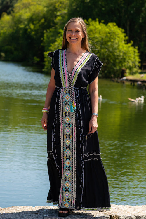 Women’s boho embroidered maxi dress with colorful tribal trim and resort-chic summer styling.