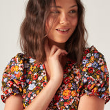 Women's multicolor floral midi dress with short puff sleeves, V-neckline, and a flattering feminine silhouette.