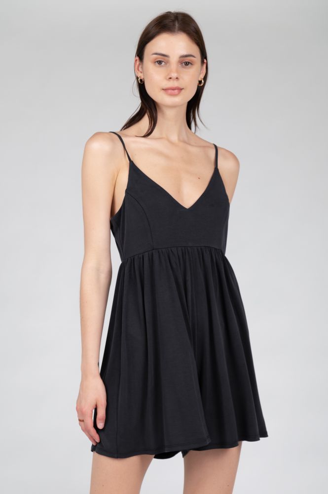 Feminine black mini dress featuring an empire waist and graceful movement.