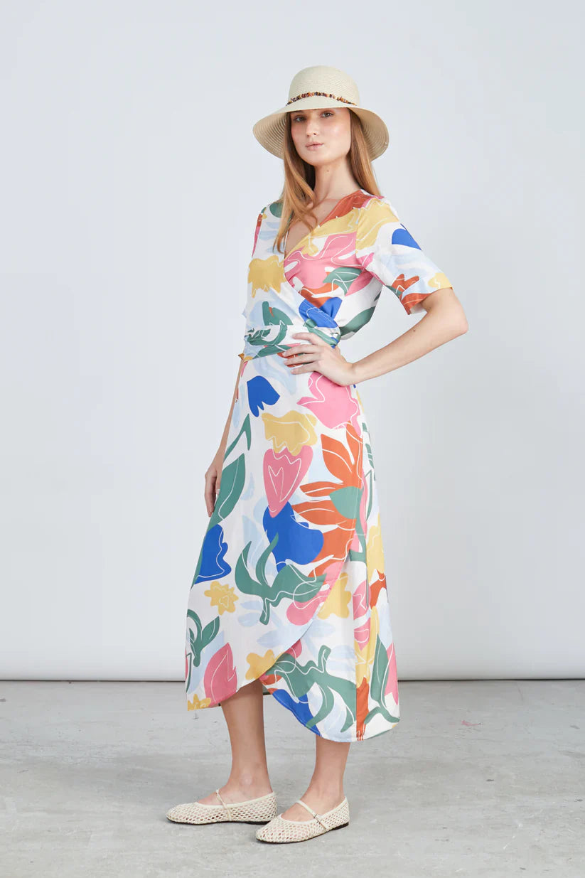 Modern wrap midi dress with bold multicolor print and chic elevated everyday resortwear aesthetic.