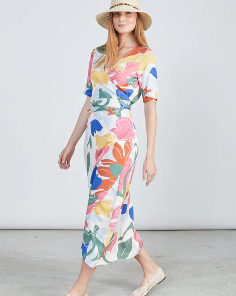 Elegant abstract print dress featuring soft wrap waist detail and modern feminine vacation styling.