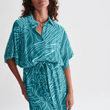 Lightweight turquoise midi shirt dress with cinched waist and oversized silhouette for beach-to-brunch styling.