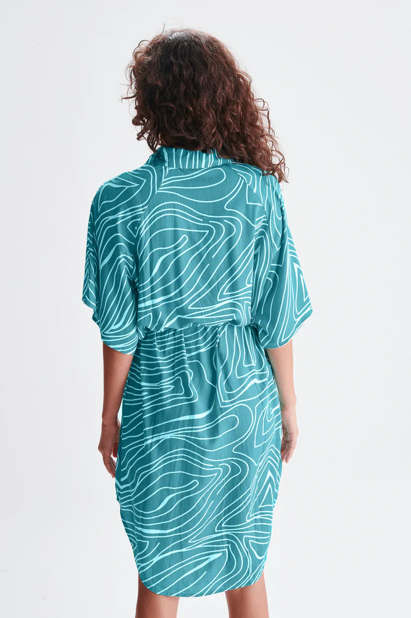 Women’s teal button-front mini dress featuring oversized fit, geometric line print, and adjustable tie waist.
