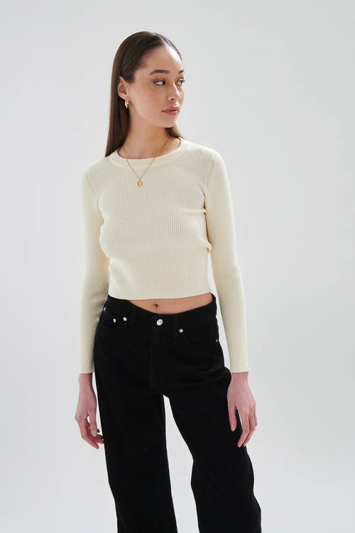 Minimalist cream knit crop top for women with long sleeves and soft stretch fabric for elevated casual wear.