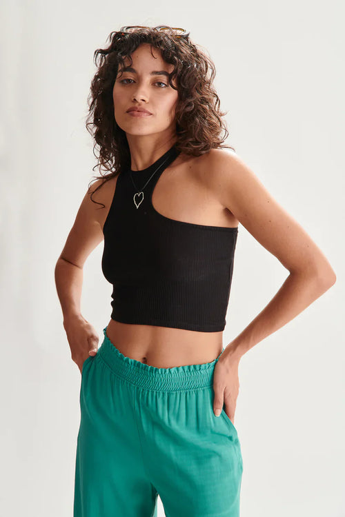 Casual luxe black asymmetrical sleeveless top with body-hugging fit and contemporary resort-inspired style.