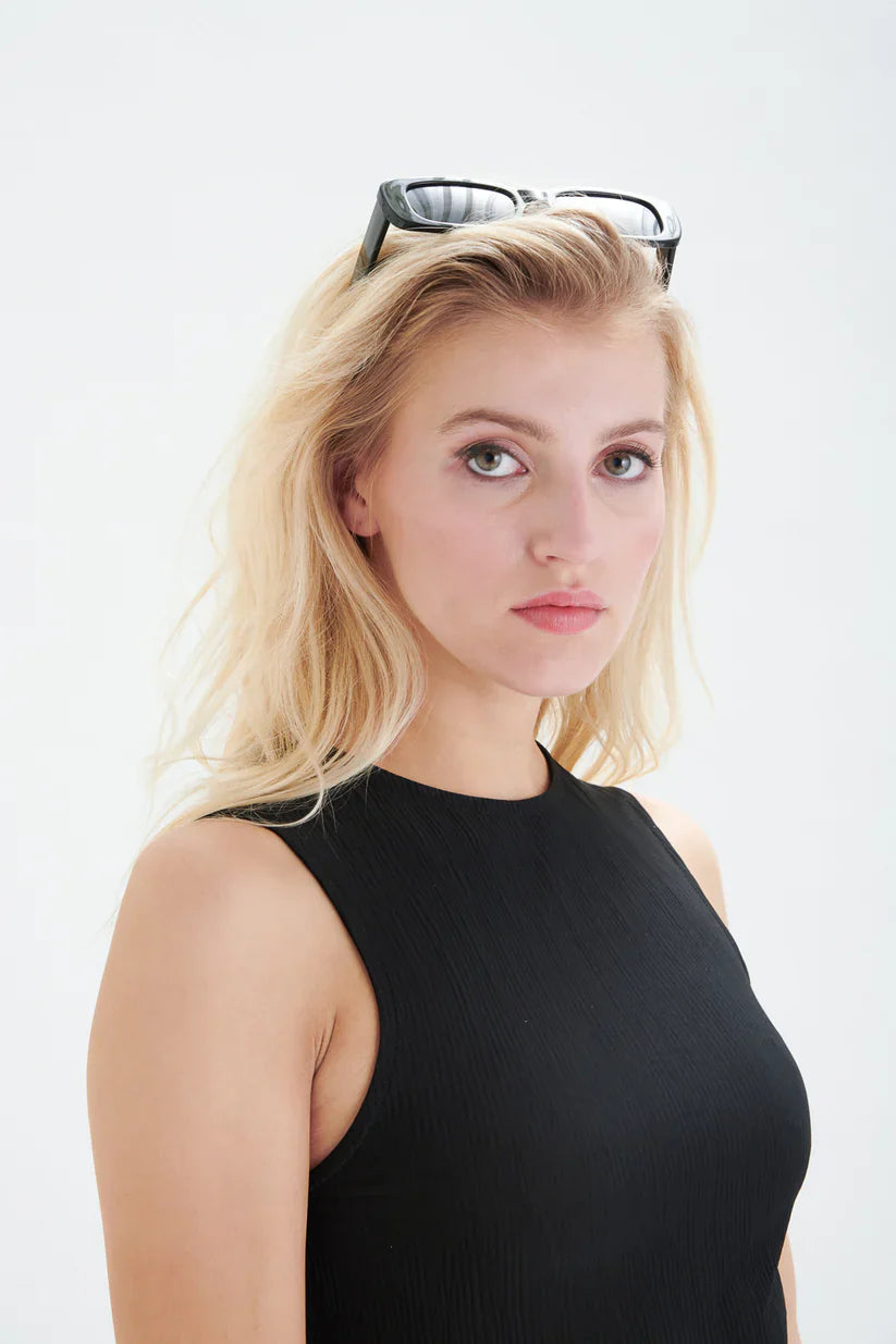 Modern black sleeveless knit dress with flattering slim fit and side slit for versatile day-to-night wear.