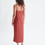 Chic rust midi dress featuring delicate straps and relaxed draped fit for modern resort wear styling.