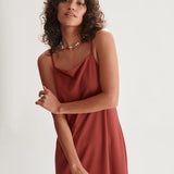 Contemporary terracotta slip dress with delicate straps and effortless relaxed vacation-ready styling.