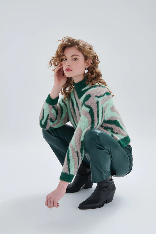 Women’s slim fit vegan leather pants in deep emerald green with modern minimalist styling for trendy wardrobes.