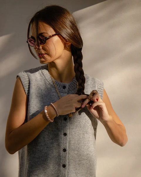 KKNEKKI Rosegold Glitter.  Woman  braiding her hair, wearing her Knekki hair tie as a bracelet.  Scrunchy as jewelry.