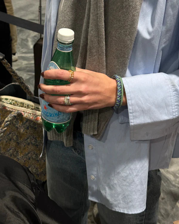 KKNEKKI Purple Green Glitter.  Woman with the most comfortable hair tie, a Kknekki on her wrist, holding a bottle of water.
