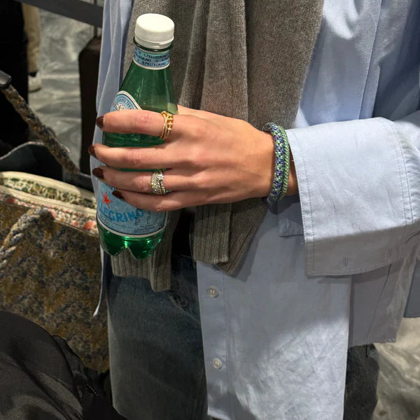 KKNEKKI Purple Green Glitter.  Woman with the most comfortable hair tie, a Kknekki on her wrist, holding a bottle of water.