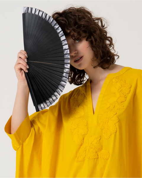 Elegant women’s handheld fan in black with minimalist striped trim and contemporary resort-inspired aesthetic.