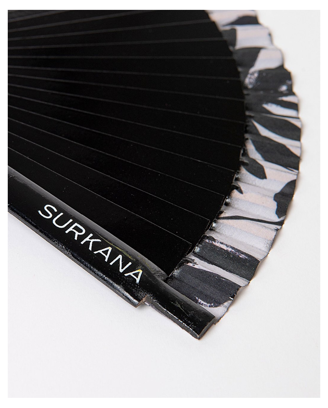 Trendy fashion accessory featuring black pleated folding fan and elevated summer street style look.