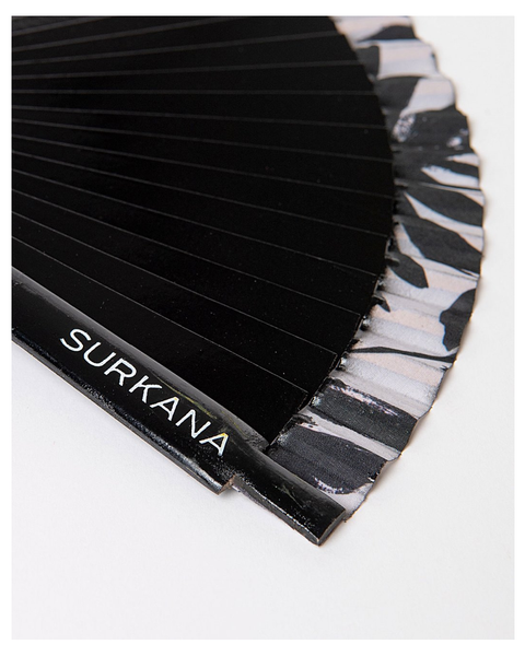 Trendy fashion accessory featuring black pleated folding fan and elevated summer street style look.