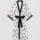 Women's ivory floral kimono cardigan featuring elegant botanical prints, black contrast trim, and a flowing open-front silhouette.
