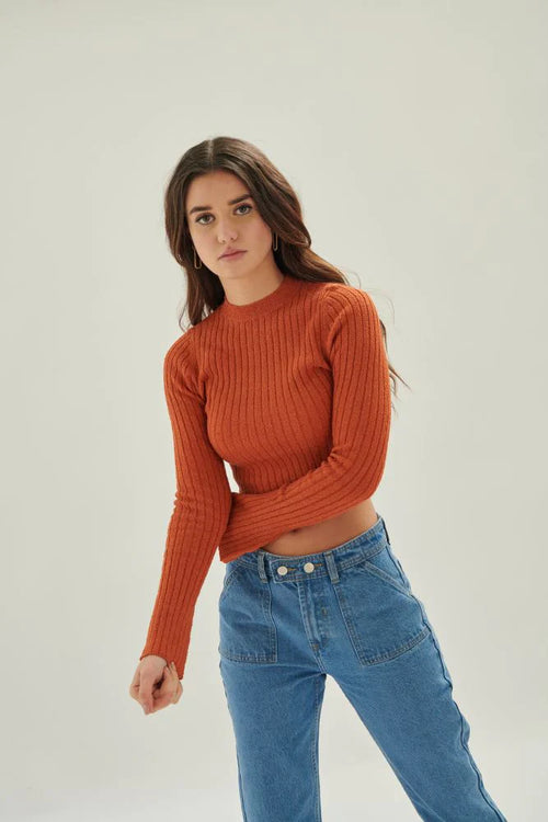 Women’s chic rust knit crop top with modern fitted silhouette and flared sleeve accents for boutique outfit styling.