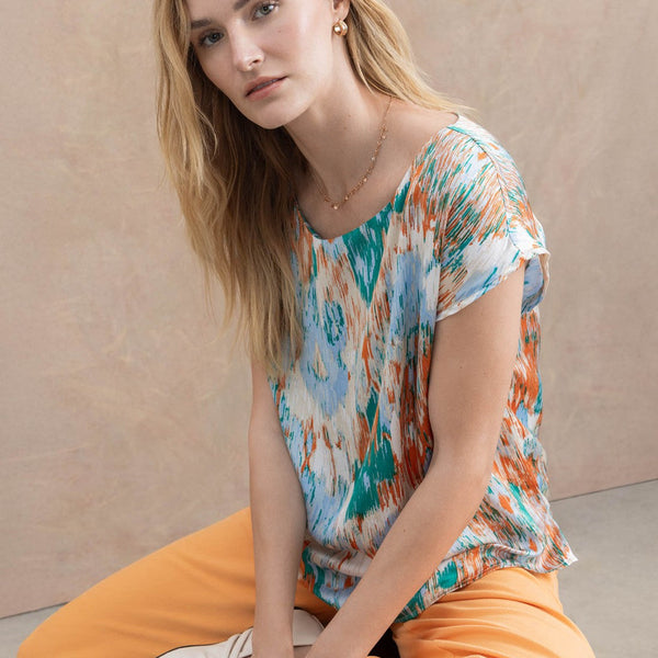 Women’s flowy short sleeve top with vibrant brushstroke print and easy everyday elegance.