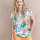 Resortwear-inspired abstract blouse with colorful tropical tones and chic laid-back styling.