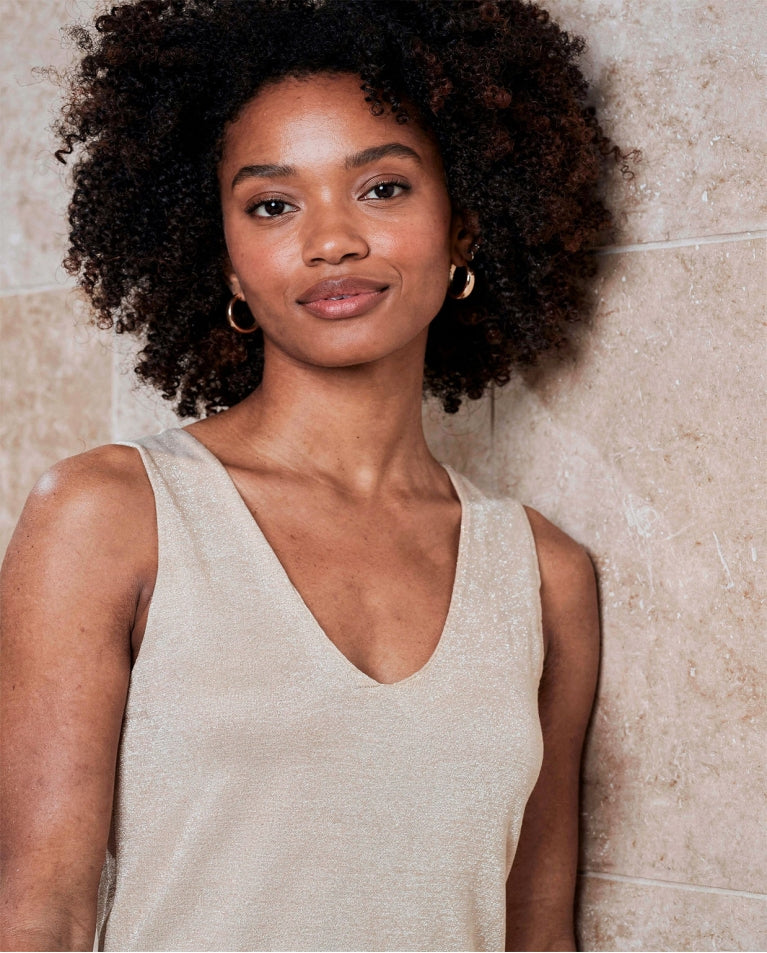 Women's neutral metallic knit camisole with wide shoulder straps, V-neckline and subtle shimmer for elevated casual and evening outfits.